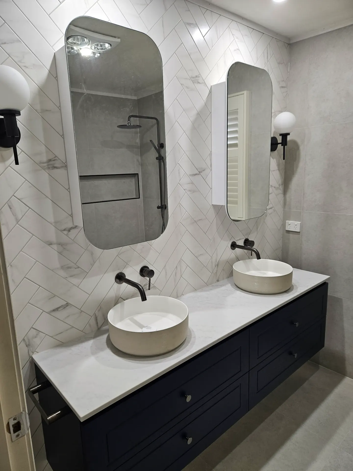 Toorak powder room — navy vanity, herringbone marble