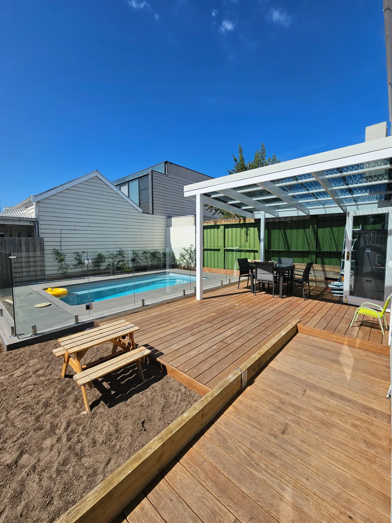 Merbau pool deck with pergola and glass balustrade