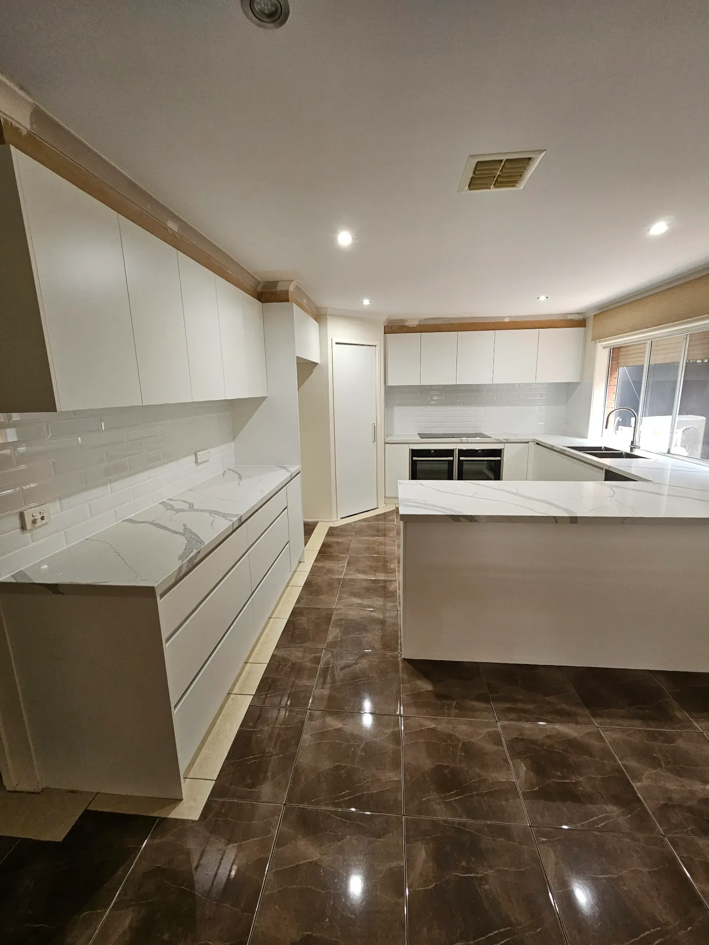 Footscray apartment kitchen — Calacatta stone, U-shape joinery