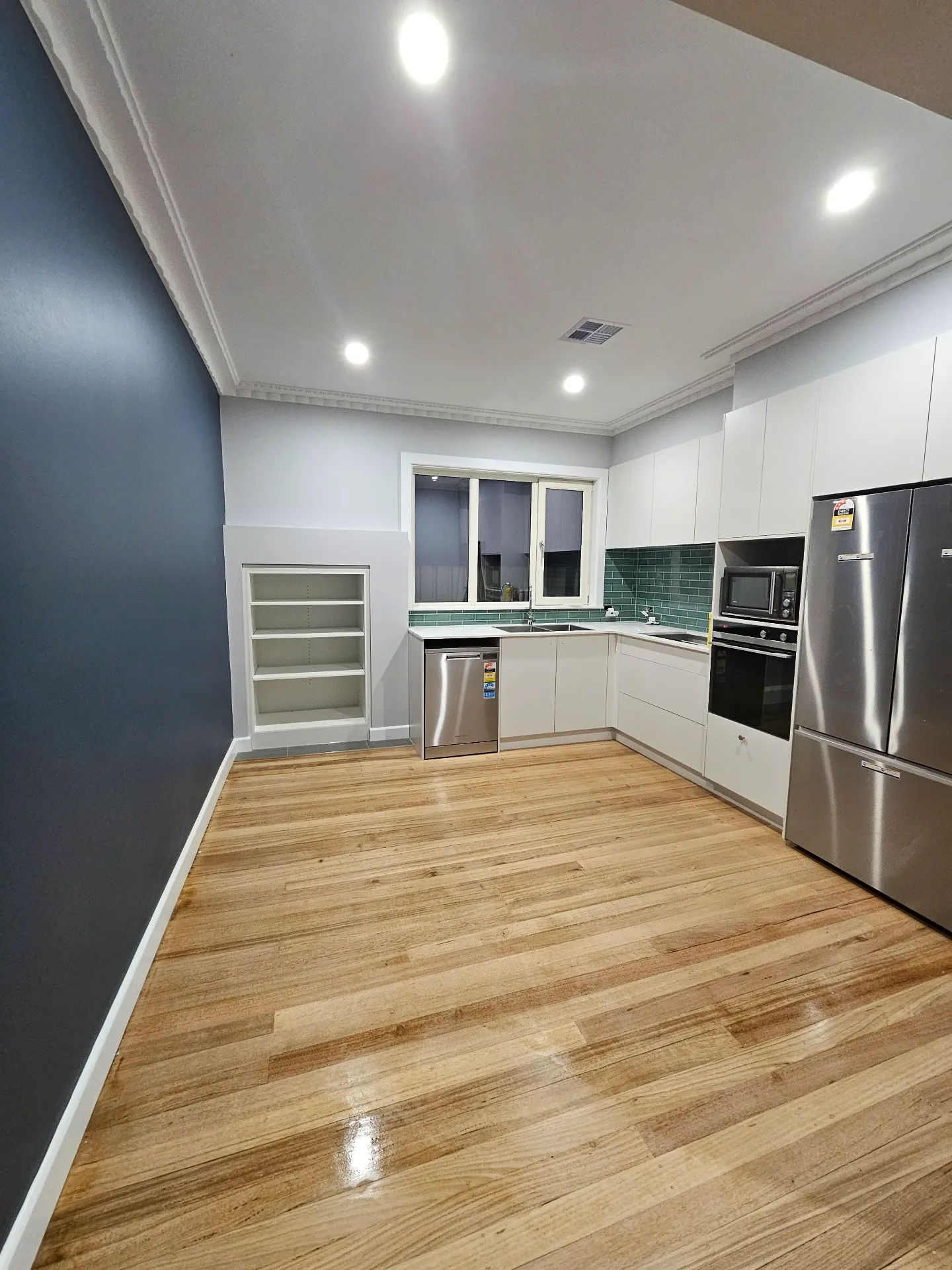 Brighton Hamptons-style kitchen — green subway, navy feature